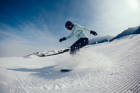 one snowboarder snowboarding in winter mountainsの写真素材