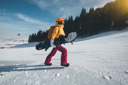 woman snowbaorder with backpack ascent on winter mountainsの写真素材