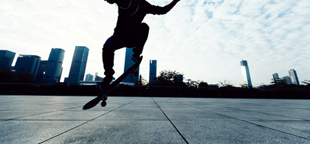 skateboarder legs jumping with skateboard at cityの写真素材