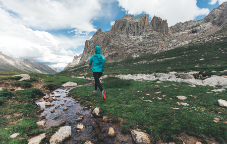 woman trail runner running in wild mountains の写真素材
