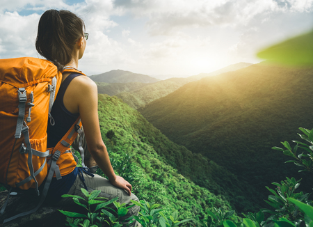 Young woman backpacker enjoy the view at mountain peakの写真素材