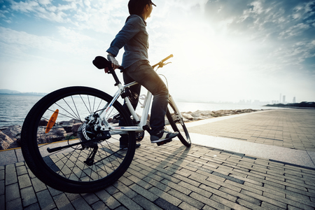 cyclist looking at the beautiful landscape while riding bike in the sunrise coast pathの写真素材