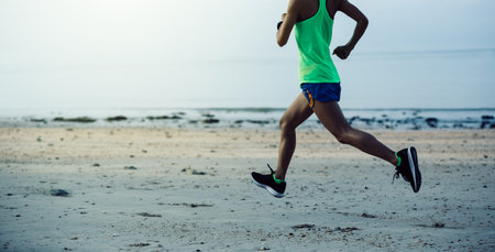 sporty young fitness woman running on beach