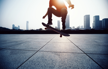 Skateboarder skateboarding at sunrise cityの写真素材