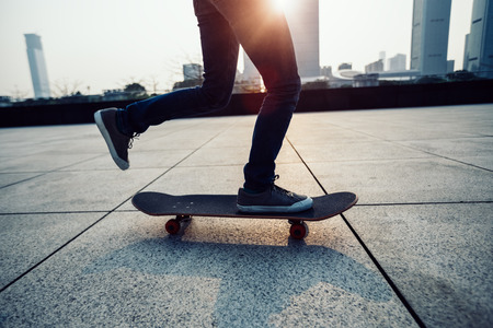 Skateboarder legs skateboarding at sunrise cityの写真素材