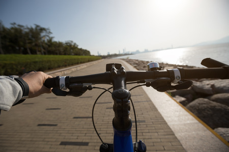 silhouette cyclist riding bike in the sunrise coast roadの写真素材
