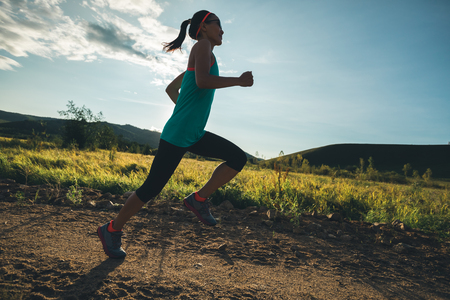Woman running on rural roadの写真素材