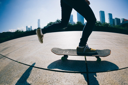 Woman practicing with skateboard at sunrise city  の写真素材