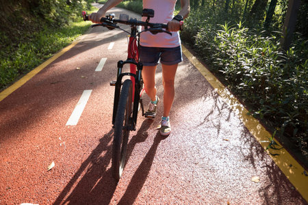 woman with mountain bike on park trail