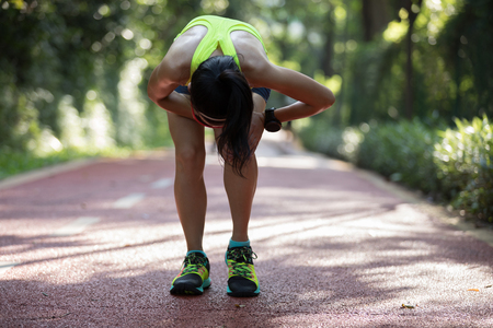 Female runner suffering with pain on sports running knee injuryの写真素材