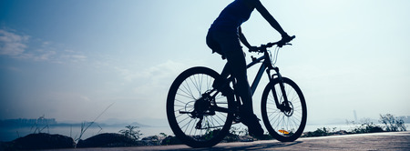Cycling woman riding mountain mike on sunrise seasideの写真素材