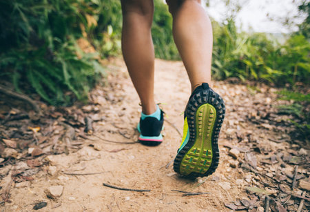 young fitness woman trail runner legs running on forest