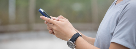 Hands using smartphone outdoorの写真素材