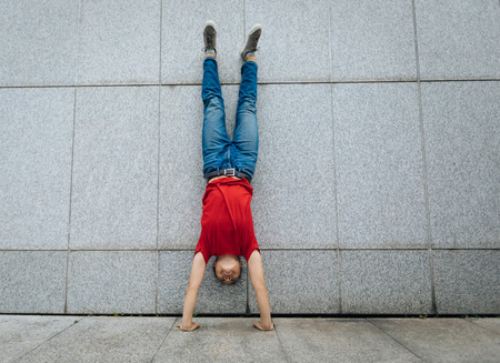 Woman doing a handstand against wallの写真素材