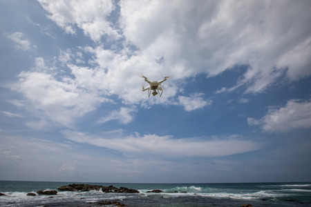 Flying drone which taking photo over seaの写真素材