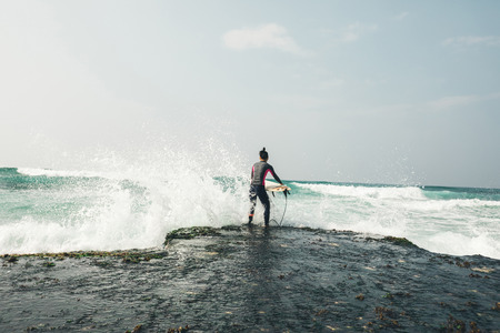 Woman surfer with surfboard going to surf the big wavesの写真素材