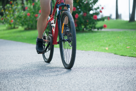 Woman riding mountain bike in tropical parkの写真素材