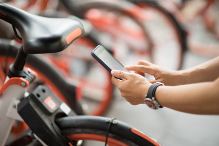 People hands using smartphone scanning the QR code of shared bike in cityの写真素材