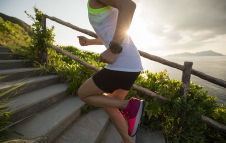Sportswoman running up on seaside mountain stairs