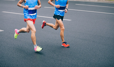 Marathon runner legs running on city road