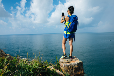 Woman Hiking In Seaside Taking A Selfie with mobile phoneの写真素材