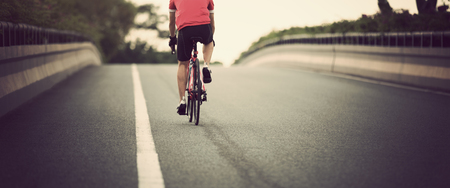 Cyclist riding bike on city roadの写真素材