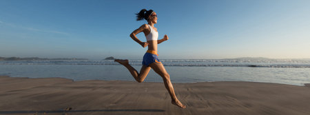 young fitness woman running at sunrise beach