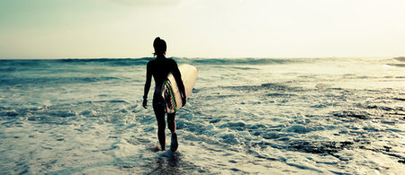 Woman surfer with surfboard going to surf