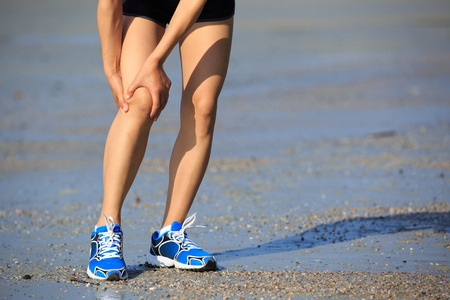 woman runner hold her sports injured kneeの写真素材