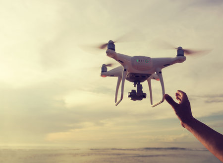 a flying drone which taking photo over sunrise sea