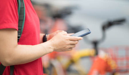 Hands using smartphone scanning the QR code of shared bike in cityの写真素材