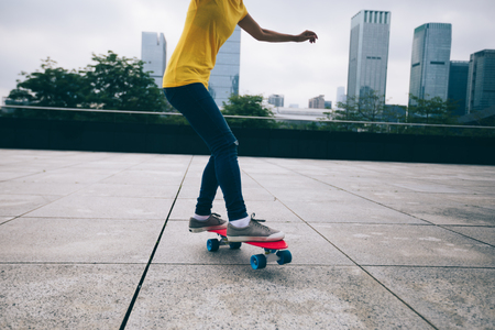 woman skateboarder skateboarding at cityの写真素材