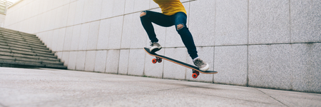 woman skateboarder legs skateboarding at cityの写真素材