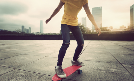 woman skateboarder skateboarding at cityの写真素材