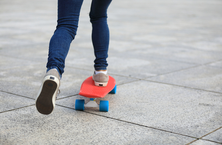 woman skateboarder skateboarding at cityの写真素材