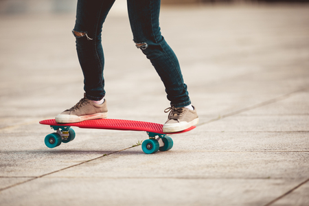 woman skateboarder skateboarding at cityの写真素材