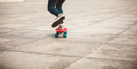 woman skateboarder skateboarding at cityの写真素材