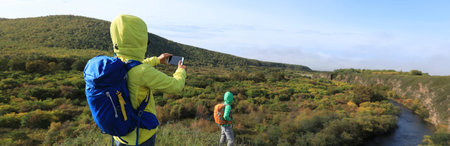 women hikers with backpack hiking in the autumn hills