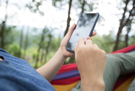 Relaxing In Hammock With Smartphoneの写真素材