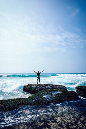 Freedom woman outstreched arms at the seasideの写真素材