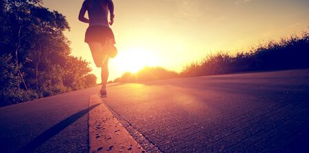 Fitness woman running on seaside trail in the morningの写真素材