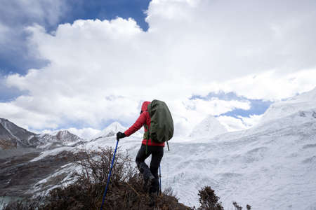 Successful woman backpacker hiking in winter mountainsの写真素材