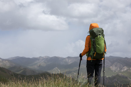 Backpacker hiking on high altitude mountain topの写真素材