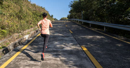 Woman runner running on mountain top on winter dayの写真素材