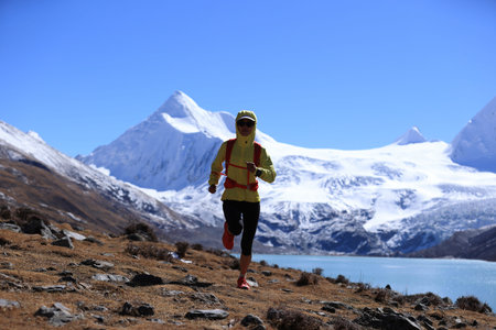 Woman trail runner cross country running  in winter mountains