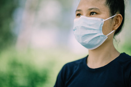 Worrying asian woman wearing face mask in city