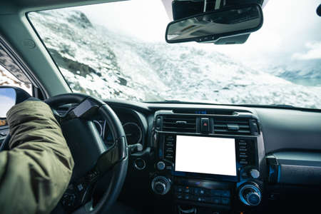 Driving off road car on snowing high altitude mountain trail on winter dayの写真素材