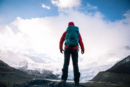 Solo woman backpacker hiking in winter mountains