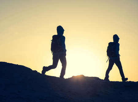Hiking on sunset desert, multiple exposure of backpacker walking in desertの写真素材