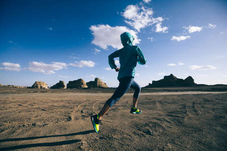 Fitness woman trail runner cross country running  on sand desertの写真素材